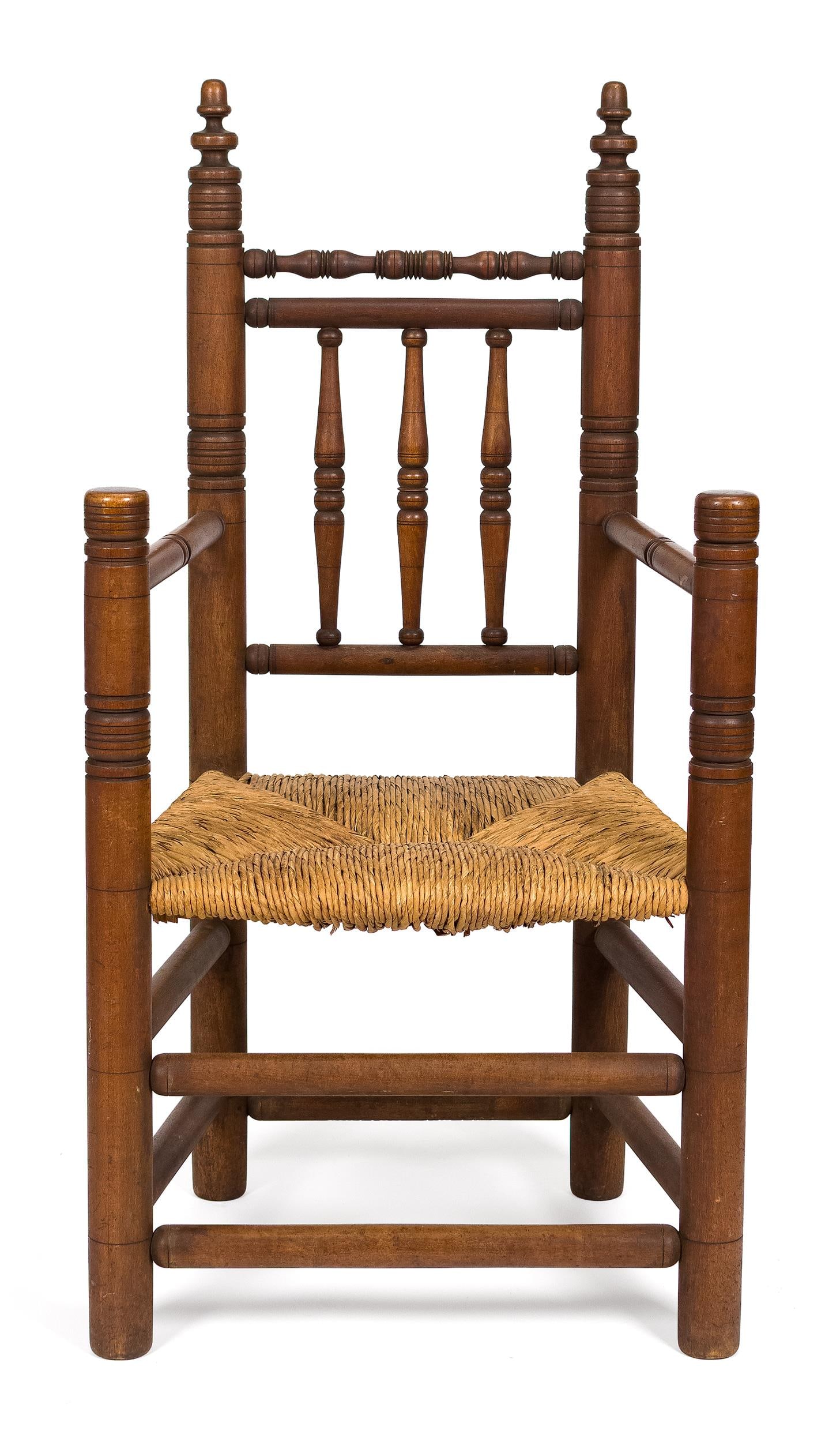 VINTAGE WALLACE NUTTING CARVER STYLE ARMCHAIR.: A ca. 1925 Wallace Nutting Carver style maple armchair. The crest rail with turned finials above three turned spindles, over a rush seat, the arms with turned handholds on ring turned supports,