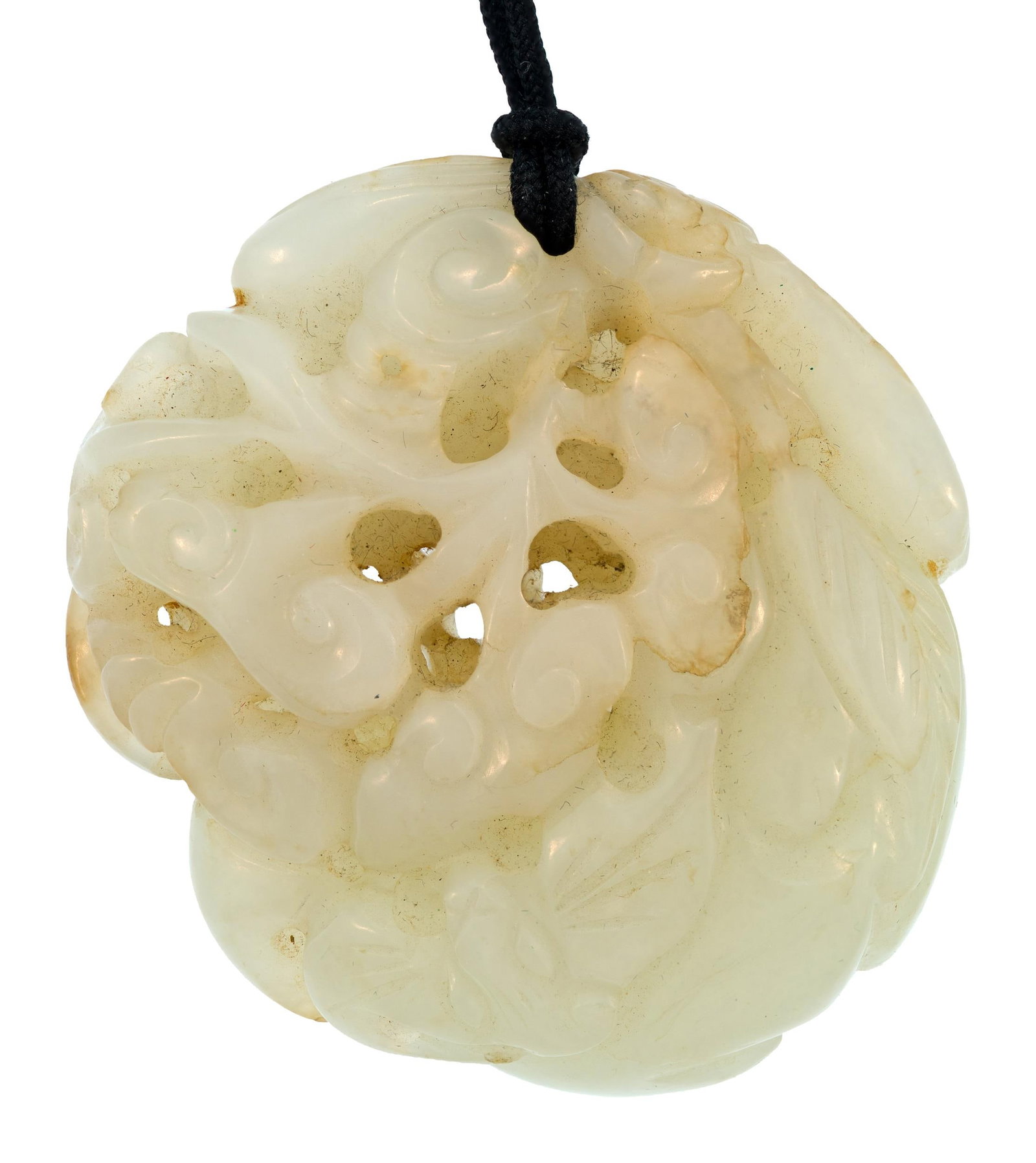 ANTIQUE CHINESE CARVED JADE PENDANT: A 19th C. or earlier Chinese carved white jade pendant of rounded form, the openwork carving depicting a bird among scrolling clouds and foliage, carved to both sides, suspended from a black cord.