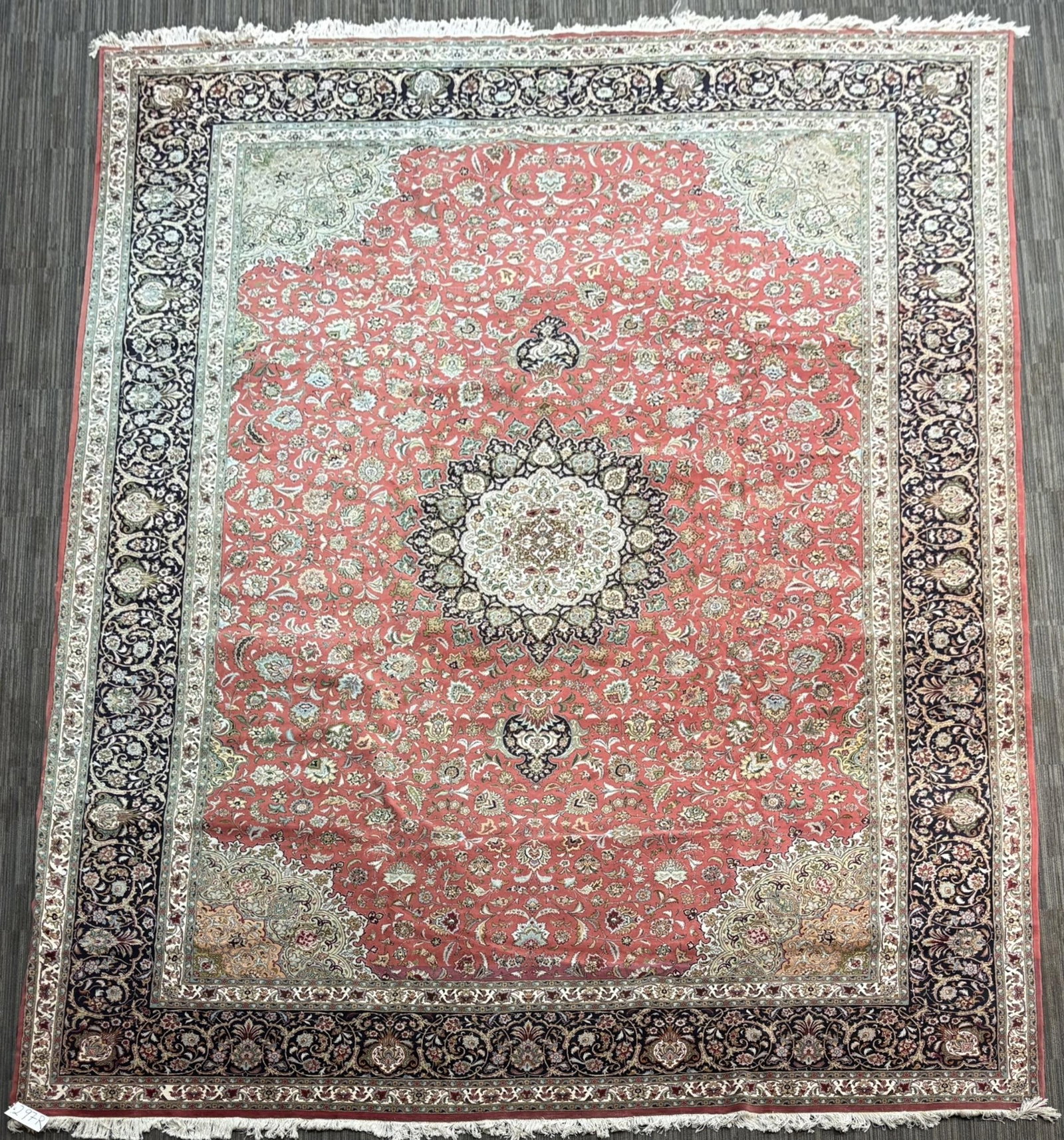 VINTAGE ORIENTAL PALACE SIZE RUG.: A vintage Persian Tabriz rug, acentral floral medallion on a red field densely decorated with scrolling vines, palmettes and flowering sprays, with pale green corner spandrels, surrounded by a dark