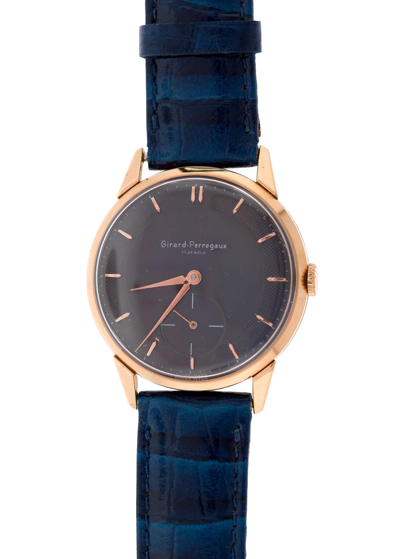 VINTAGE 18K GOLD PURPLE DIAL GIRARD PERREGAUX WATCH.: A vintage, 18k rose gold (case-back is stamped), Girard Perregaux wrist watch with dark purple dial, 36mm case, 17 jewel mechanical movement, #1209625, blue leather strap, 9 1/4 inches long.