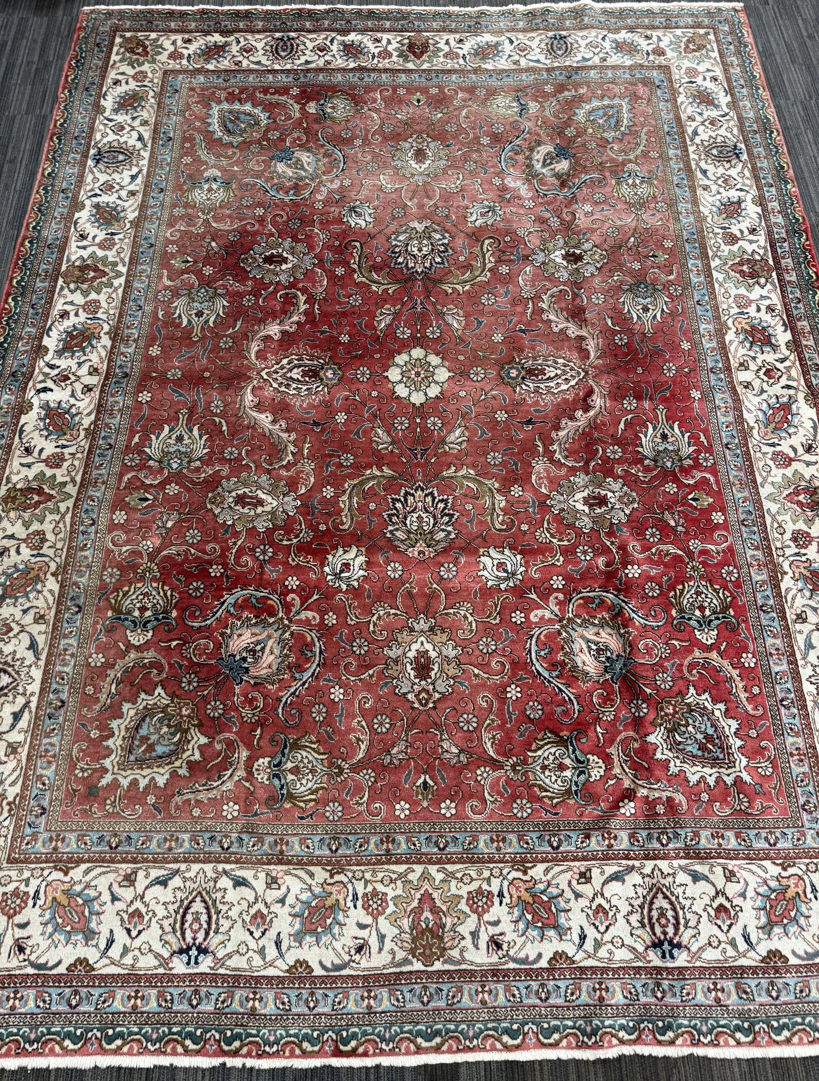 VINTAGE ORIENTAL ROOM SIZE RUG.: Vintage Oriental room size rug, with a soft coral-red field decorated with an allover pattern of large floral sprays, palmettes, and scrolling vines in ivory, pale blue, green, and muted brown tones. 