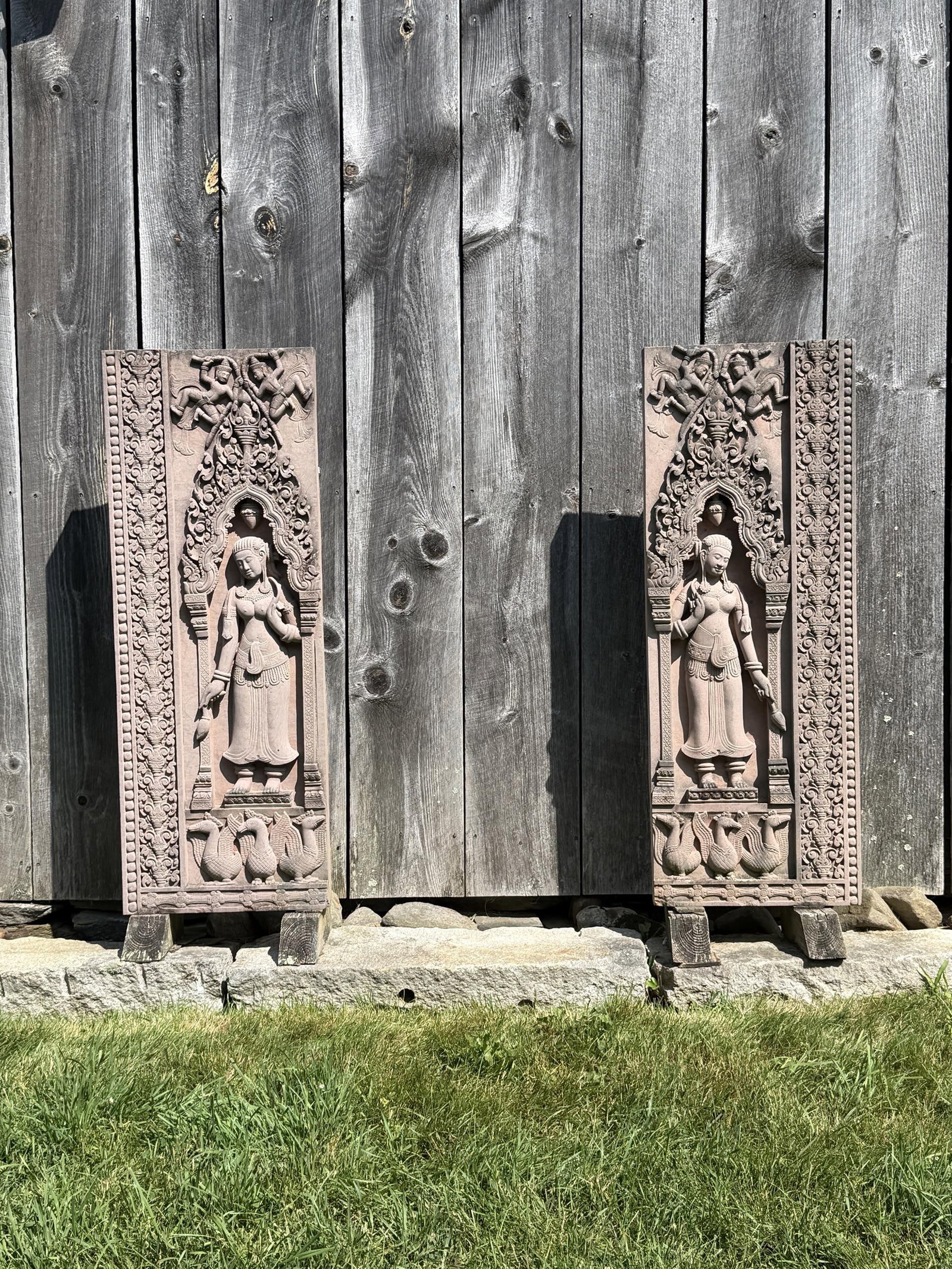TWO VINTAGE CARVED SANDSTONE FRIEZES.: Two vintage vertically orientated deep relief carved sandstone friezes, after early Angkor Wat temple carvings. 54”H x 20”W.