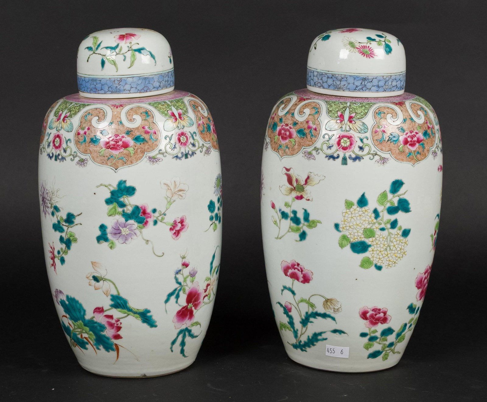 PR. 19TH C. CHINESE PORCELAIN COVERED URNS.: A pair of antique Chinese famille rose porcelain covered jars. Each ovoid jar painted on a white ground with scattered polychrome flowers and butterflies, beneath a gilt scrollwork and cartouche shoul