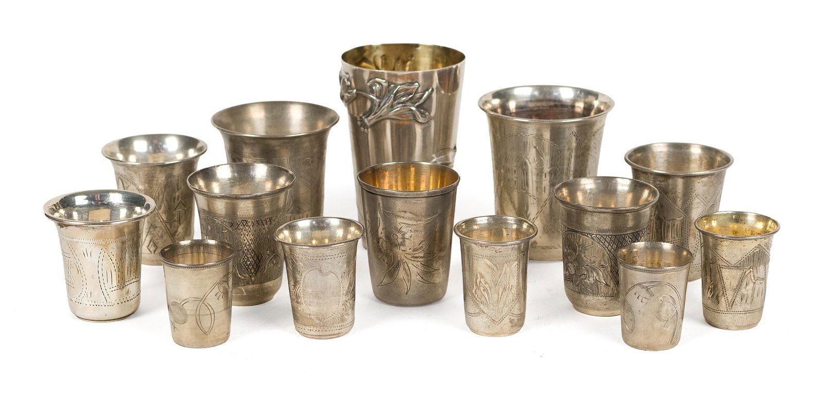 14 SILVER KIDDUSH CUPS.: Collection of 14 silver Kiddush cups of varying sizes and forms, several with engraved or chased decoration, including floral and foliate motifs; some with gilt-washed interiors. One marked sterling, 