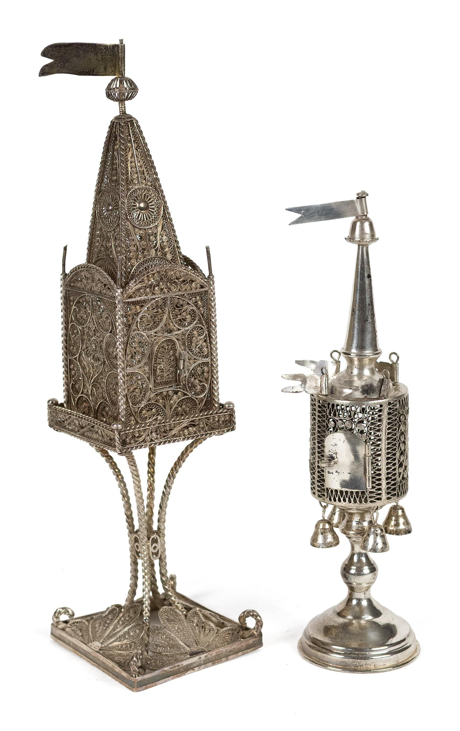 TWO ANTIQUE JUDAICA SILVER FILIGREE SPICE TOWERS.: Two antique Judaica silver (800 or similar purity) besamim or spice towers, each of architectural form, flag finials, filigree decoration, and small doors. Taller with square body, a raised on an