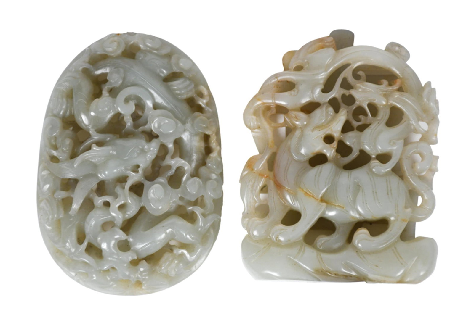 ANTIQUE CHINESE CARVED CELADON JADE PLAQUES, 2PCS.: Two antique Chinese pale celadon jade reticulated plaques, each carved with russet inclusions throughout, including:a reticulated oval plaque carved in openwork with a qilin amid auspicious clouds