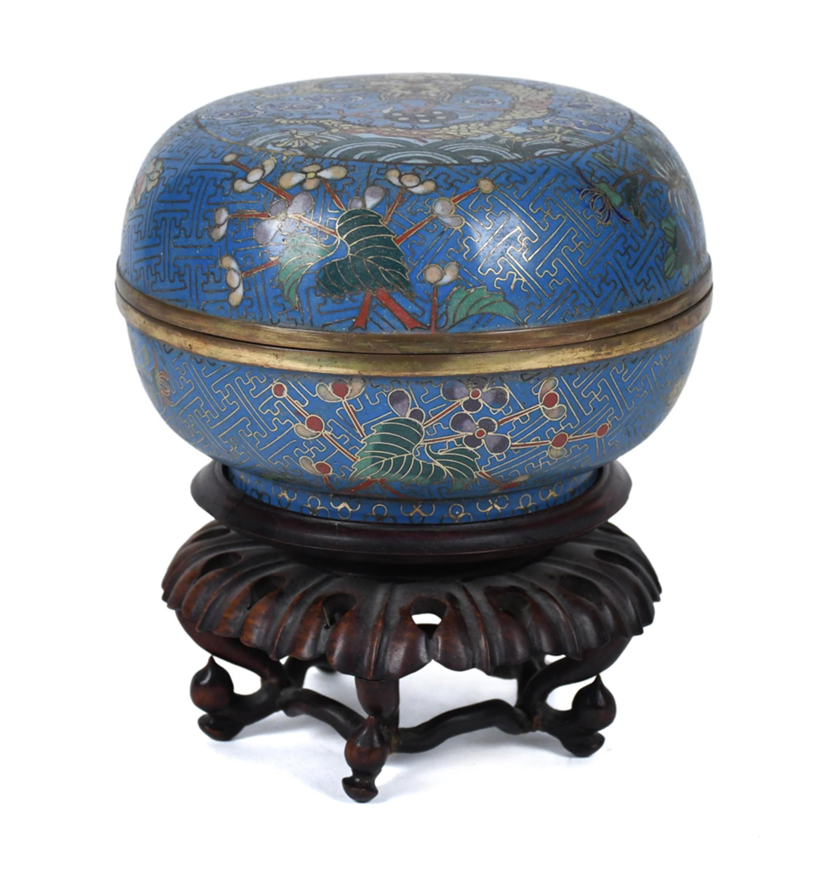 ANTIQUE CLOISONNE JAR: An antique cloisonné covered box on a turquoise ground, decorated overall with a fret-pattern ground bearing polychrome floral sprays of prunus and peony. The domed lid centered with a yellow dragon 
