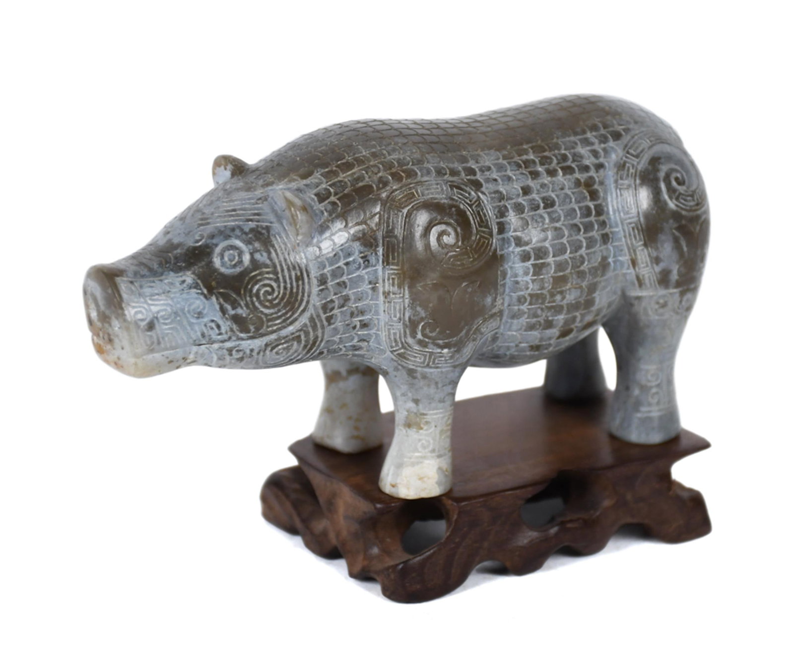 CHINESE HARDSTONE CARVED PIG FIGURINE: A vintage Chinese hardstone pig figure carved in archaic style, the body entirely covered with a crosshatched scale pattern and taotie spiral motifs at the shoulders, haunches, and snout, the legs ban