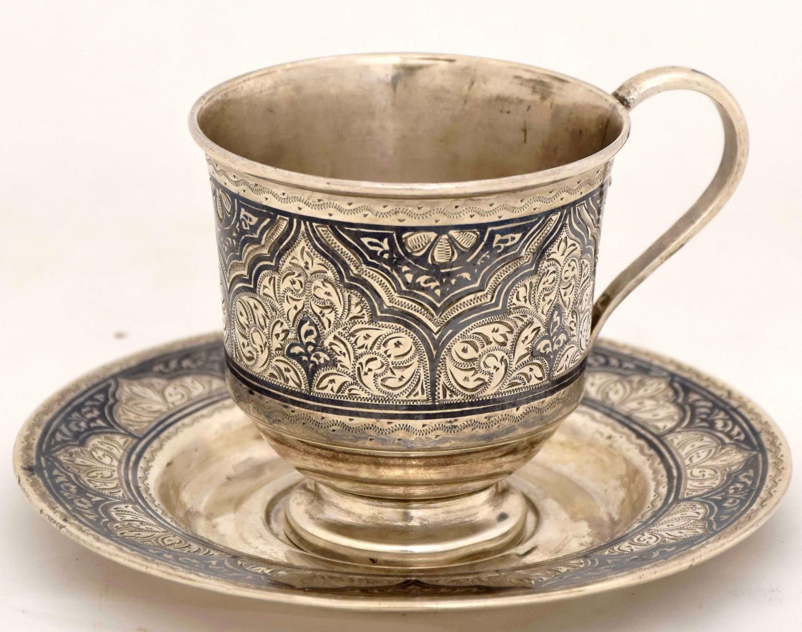 [Russian]. Silver cup and saucer with floral ornament. - Russia, Moscow, 20th century. - 9x6,5x7 cm.: [Russian]. Silver cup and saucer with floral ornament. - Russia, Moscow, 20th century. - 9x6,5x7 cm. Weight: 187 g. Silver; casting, niello, engraving. Hallmark of .84 fineness, "head in kokochnik to 