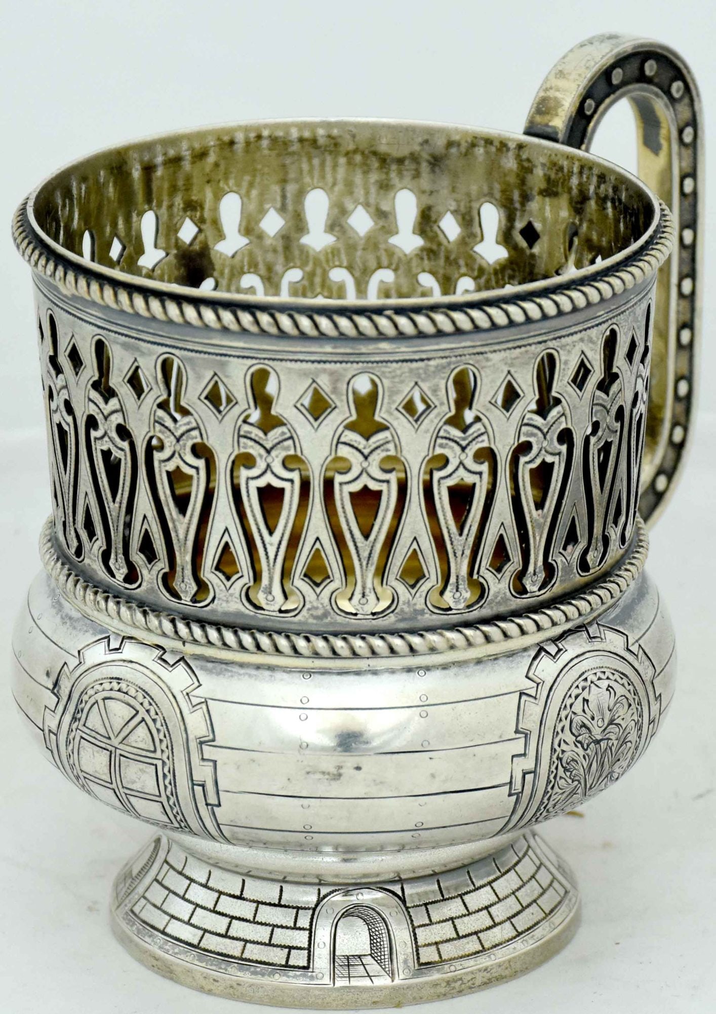 [Russian Revival style]. Silver cup holder. - Russia, 20th century. - 10x7,5x10 cm. Weight: 231 g.: [Russian Revival style]. Silver cup holder. - Russia, 20th century. - 10x7,5x10 cm. Weight: 231 g. Silver; casting, minting, engraving. Hallmark of .84 fineness, "double-head eagle", assayer's initial