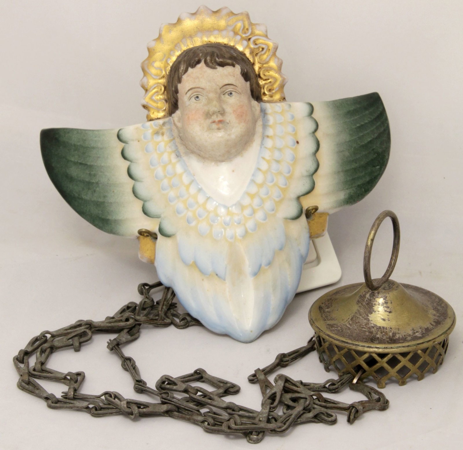Russian icon lamp ('lampada') "Cherub". - Russia (?), 20th century. - 16x14 cm. Chain: 57 cm.: Russian icon lamp ('lampada') "Cherub". - Russia (?), 20th century. - 16x14 cm. Chain: 57 cm. Porcelain; painting. Steel chain.
