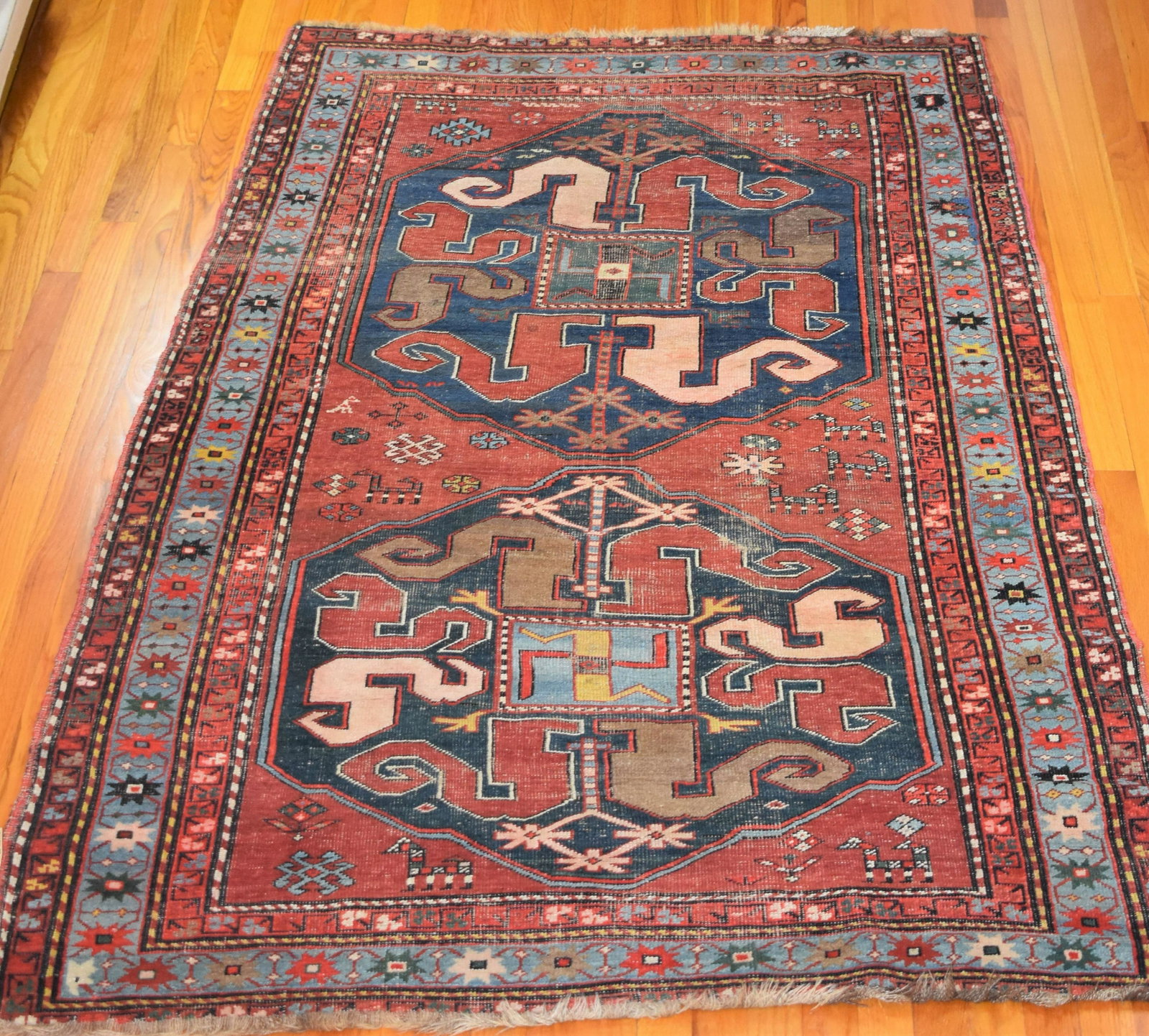 1900 Kazak Rug 3: 1900 Kazak Rug 3'10" x 7'8" rust field field w/ 2 medallions, animal figures, blue main border. Estimate $1800-$2400 See attached photos as evidence of condition and details.