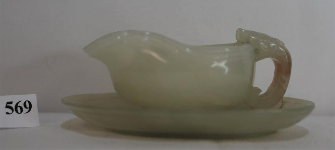 White Jade Pitcher and Saucer Circa 1900s: This white jade pitcher with matching underplate set has a brown skin incorporated in the dragon handle. This was said to have come the collection of a man who was in China during the Boxer Rebellion 