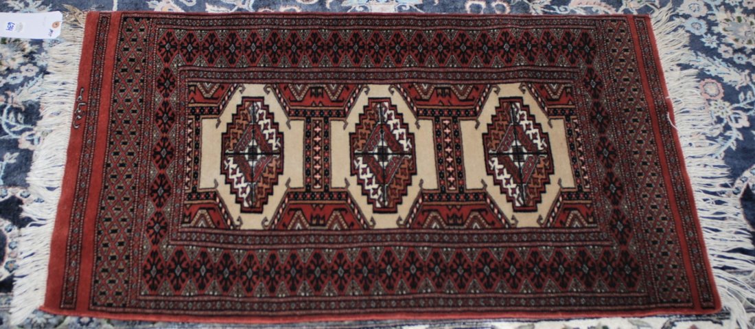 Bokhara Pakistan Oriental Rug 2 x 3.5 feet: This Oriental rug is originally from Bokhara, Pakistan and is brown and beige over a red background. The rug measures: 2 x 3.5 feet. This rug was purchased from Hagopian in Ann Arbor, Michigan on July