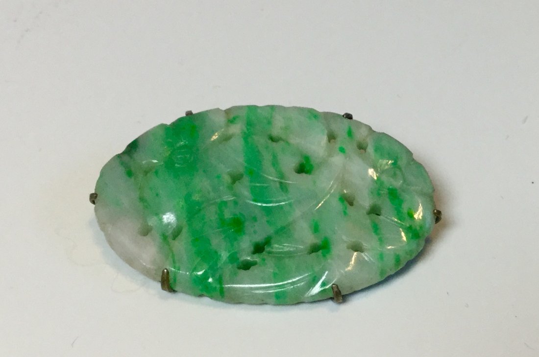 Qing dynasty Chinese Export Hand made brooch jadeite: One brooch in jadeite with green and white coloration, carved in floral design, Measures approx 1 1/2 in by 1 in.