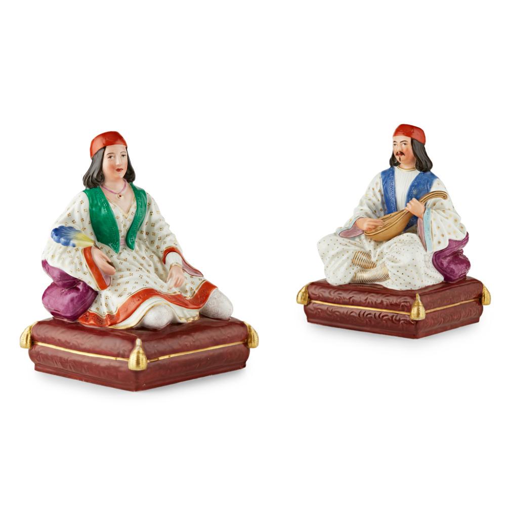 PAIR OF PORCELAINE DE PARIS FIGURAL INCENSE HOLDERS: FRENCH FOR THE TURKISH MARKET, 19TH CENTURY modelled as a seated sultan with a banjo and a sultana with a fan, in polychrome and gilt enamels, with openings to the tops of their turbans, all raised on