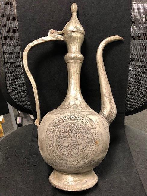 LARGE DECORATIVE METAL JUG QAJAR: Description: Large Decorative metal Jug Qajar, Lovely design, Height 44 CM, man riding a horse. Location: United States, Beverly Hills.