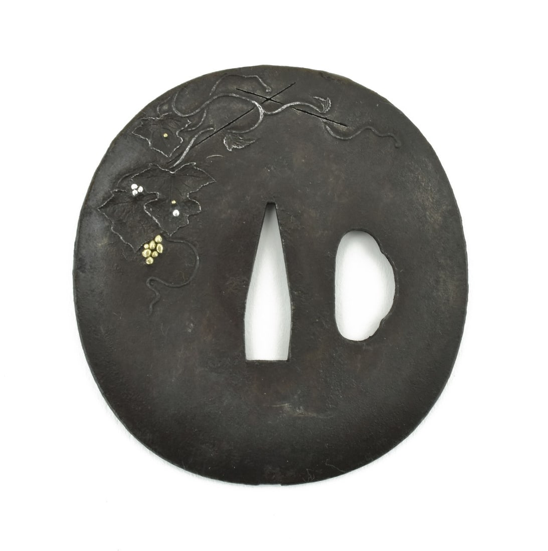 IRON TSUBA: Iron Tsuba ) Description: Iron Tsuba. Round or Maru Gata. Theme of flowers and tendrils with gold and silver highlights. Unsigned. Boxed. Vertical height 2 ¾” (7.2 cm). Wakizashi