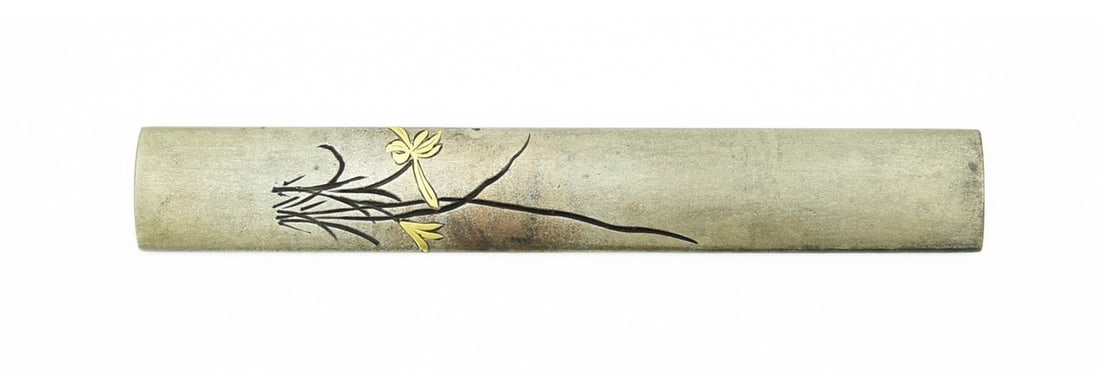 SILVER KODZUKA: Silver Kodzuka Description: Silver Kodzuka carved with irises in katakiribori and gold inlay. Signed: Goto Mitsu Toshi with kao. Size: Length 3. 75 inch Accessories: None Accessories Notice: