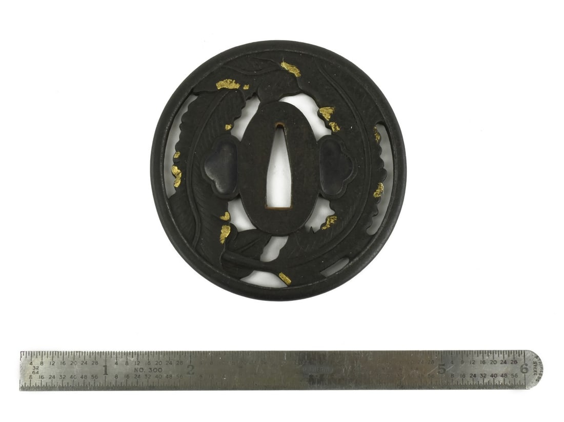 IRON TSUBA: Iron Tsuba Description: Iron Tsuba. Sukashi decorated with leaves with gold highlights. Signed: Moto Yuki. Katana size (Kao). Boxed. Shakudo Hitsu-Ana. Size: 8 centimeters in diameter 