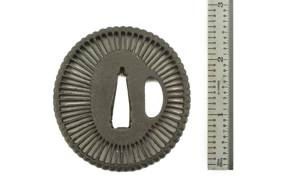 IRON TSUBA: Iron Tsuba Description: Iron Tsuba. Sukashi with petal design. Unsigned. Tanto or wakizashi size. Vertical dimension 2 5/8”. Size: Vertical dimension 2 5/8”. Accessories: None
