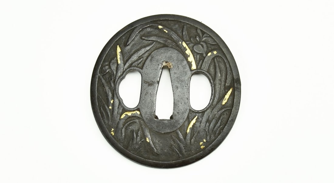 IRON TSUBA FOLIAGE WITH GOLD HIGHLIGHTS: Iron Tsuba Foliage with gold highlights Description: Iron Tsuba Foliage with gold highlights. Signed: Bushu Ju Masa Tsune. Size: None Accessories: None Accessories Notice: When purchasing pre-owned