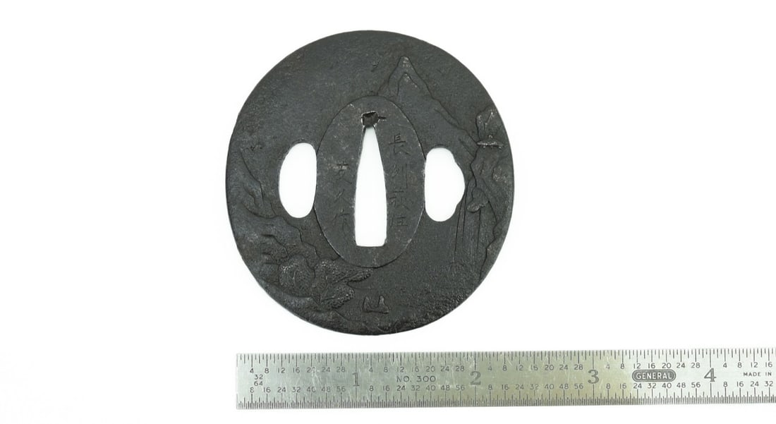 IRON TSUBA: Iron Tsuba Description: Iron Tsuba. Mountain landscape scene. Signed: Choshu Hagi Ju Tomo Hisa Saku. Wakizashi size. Size: Length 2 .25inches Accessories: None Accessories Notice: When purchasing pr