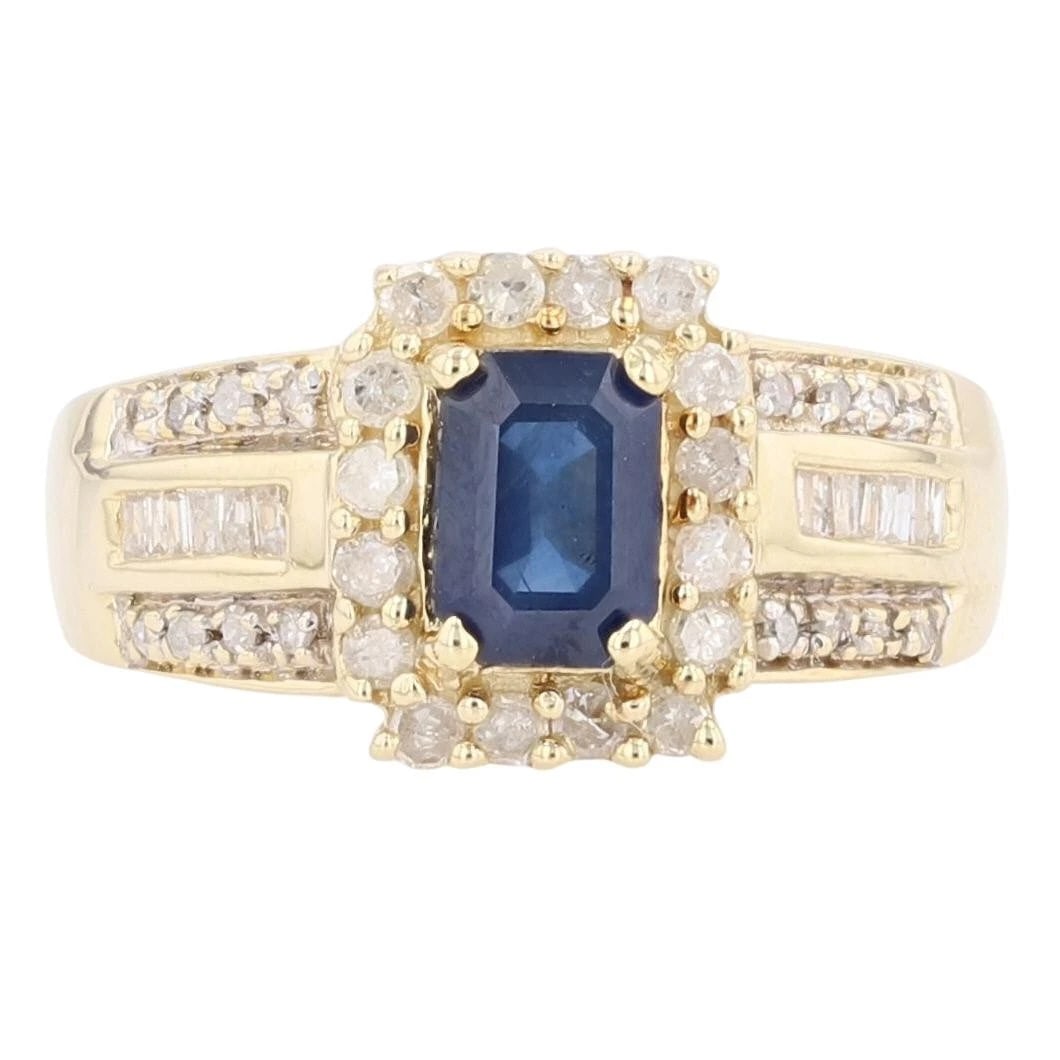 EMERALD CUT SAPPHIRE AND DIAMOND HALO RING: Emerald Cut Sapphire and Diamond Halo Ring Brand: Unbranded Type: Ring Material: 14k Yellow Gold Main Stone/Creation Sapphire Color: Main Stone Color: Medium Dark Slightly Grayish Blue Size: 7 US