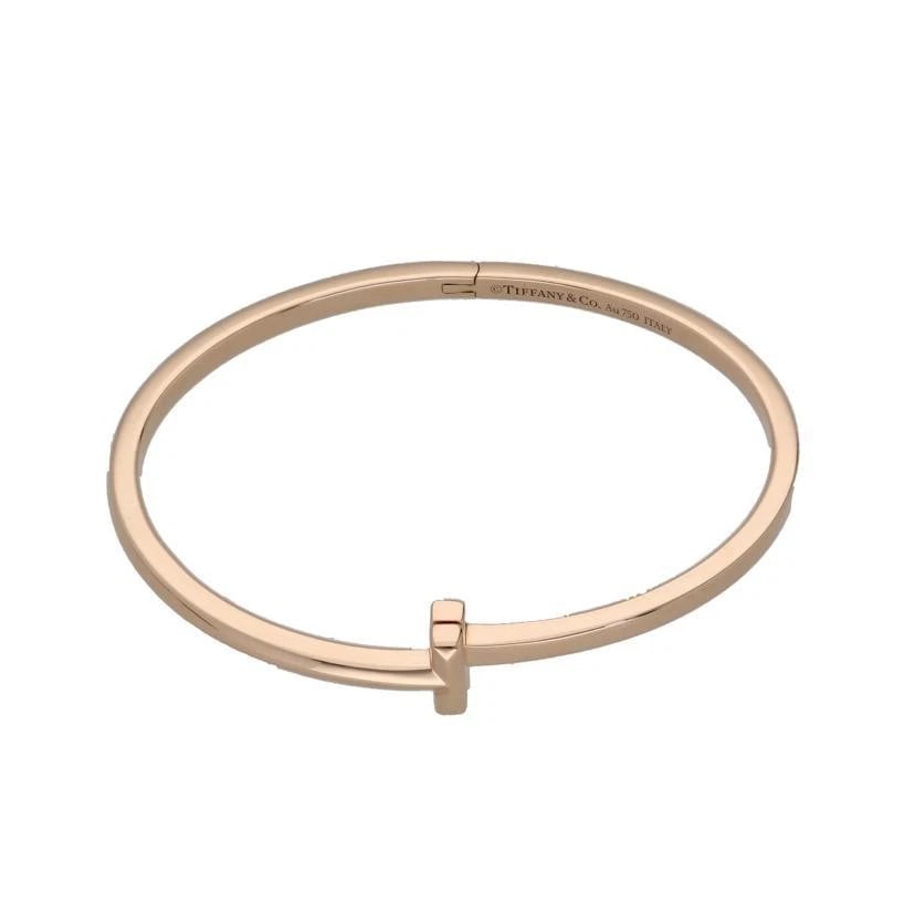 TIFFANY & CO. T ONE-HINGED NARROW 750 GOLD BRACELET: Tiffany & Co. T One-Hinged Narrow 750 Gold Bracelet Brand: Tiffany & Co. Type/Style: Bracelet Material: Metal Purity 750, Metal Gold, Color: Gold Size: BangleWrist circumference: Approx. 15cm Acc