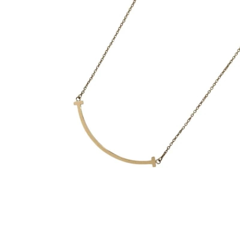 TIFFANY & CO. T SMILE K18 PINK GOLD NECKLACE: Tiffany & Co. T Smile K18 Pink Gold Necklace Brand: Tiffany & Co. Type/Style: Necklace Material: Metal Purity K18, Metal Pink Gold, Main Stone/Creation Natural Color: Pink Gold Size: Width: Approx