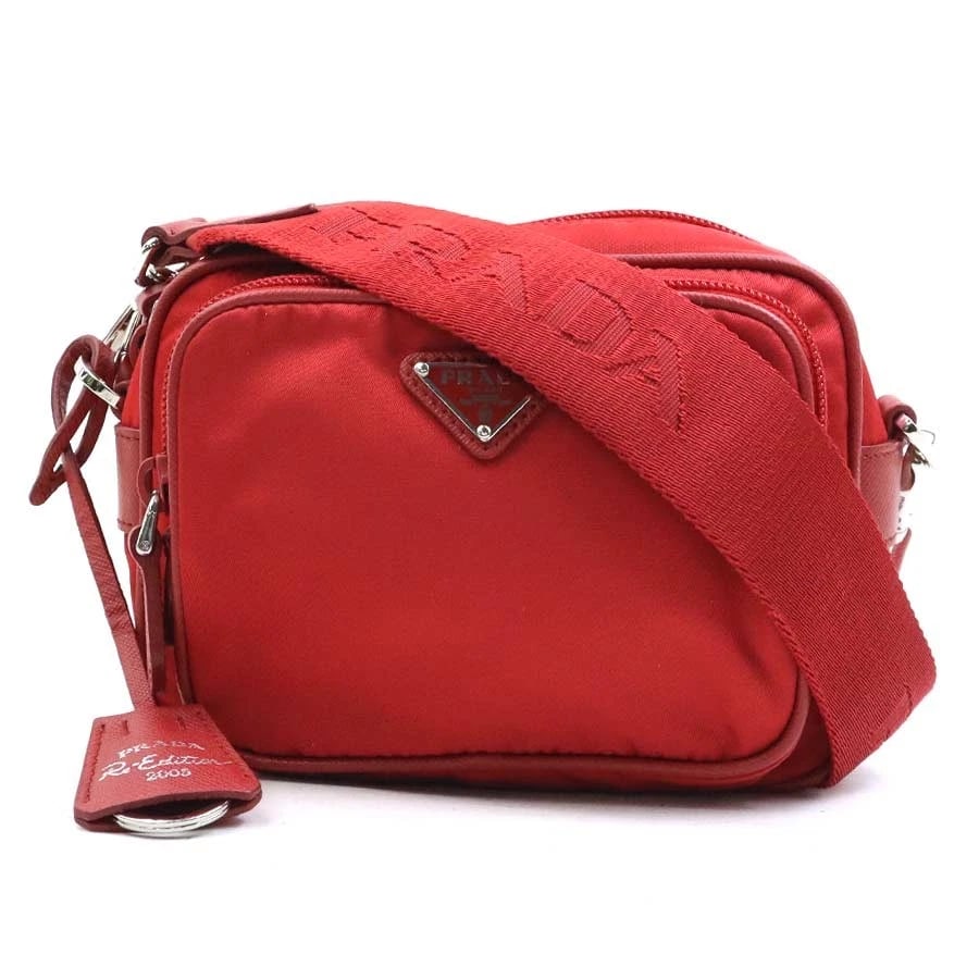 PRADA CROSSBODY SHOULDER BAG RED NYLON/SILVERTONE SHOULDER BAG: PRADA Crossbody Shoulder Bag Red Nylon/Silvertone Shoulder Bag Brand: PRADA Type: Shoulder Bag Material: Nylon Color: Red Size: W:6.3inx H:4.7inx D:2.4in Shoulder Length:?Max? 55.1in Accessories: