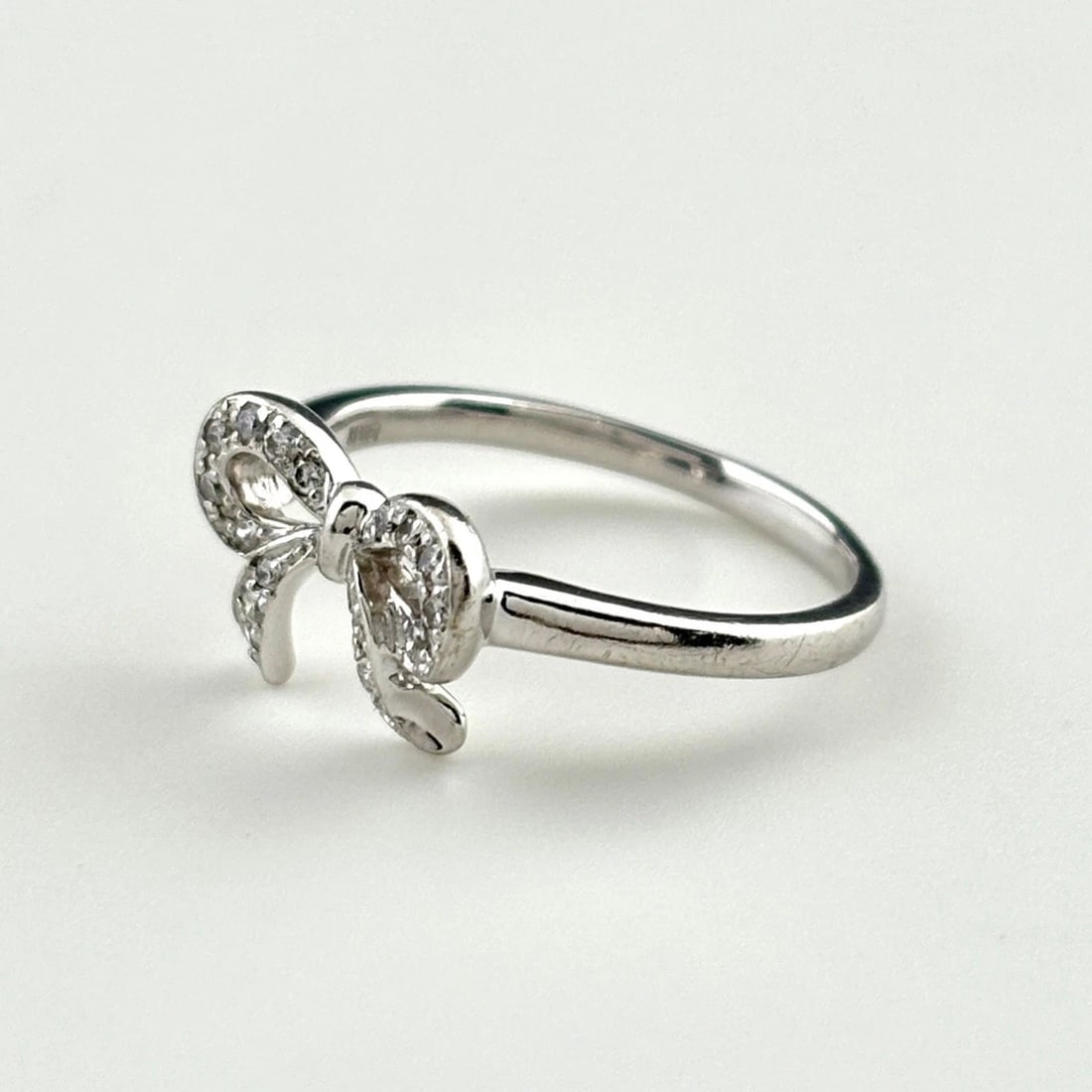 RIBBON MOTIF DESIGN WG WHITEGOLD MELEE DIAMOND RING: Ribbon motif design WG WhiteGold Melee diamond Ring Brand: Unbranded Type: Ring Material: 18K, Color: White Gold Size: US 4.5 to 5 Accessories: None Accessories Notice: When purchasing