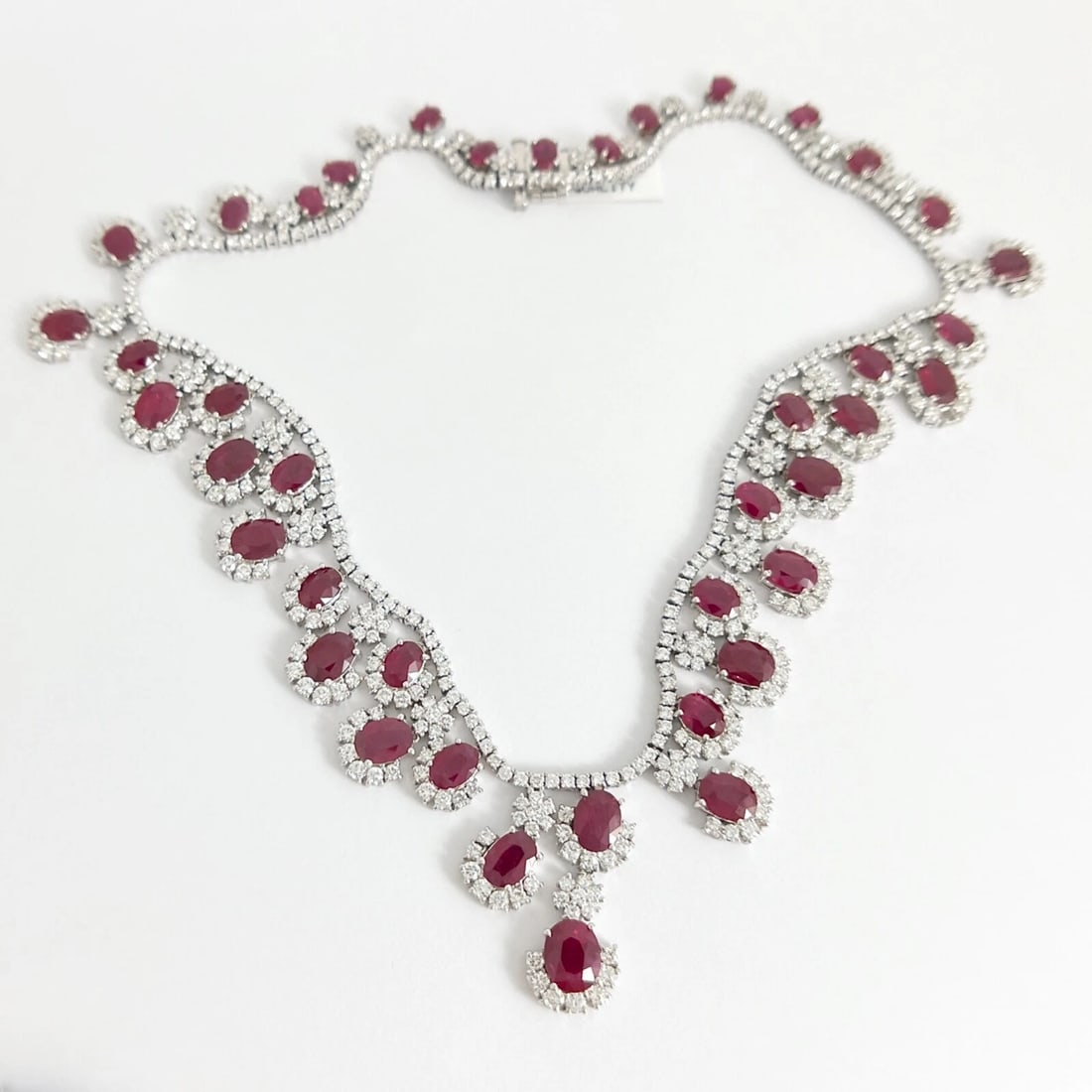 OVAL RUBY DIAMOND HALO GEMSTONE FESTOON BIB NECKLACE: Oval Ruby Diamond Halo Gemstone Festoon Bib Necklace Brand: Unbranded Type: Necklace Material: 18K White Gold, Main Stone/Creation Natural Color: Red Size: Length: 16 inches Width: 1.25 inches
