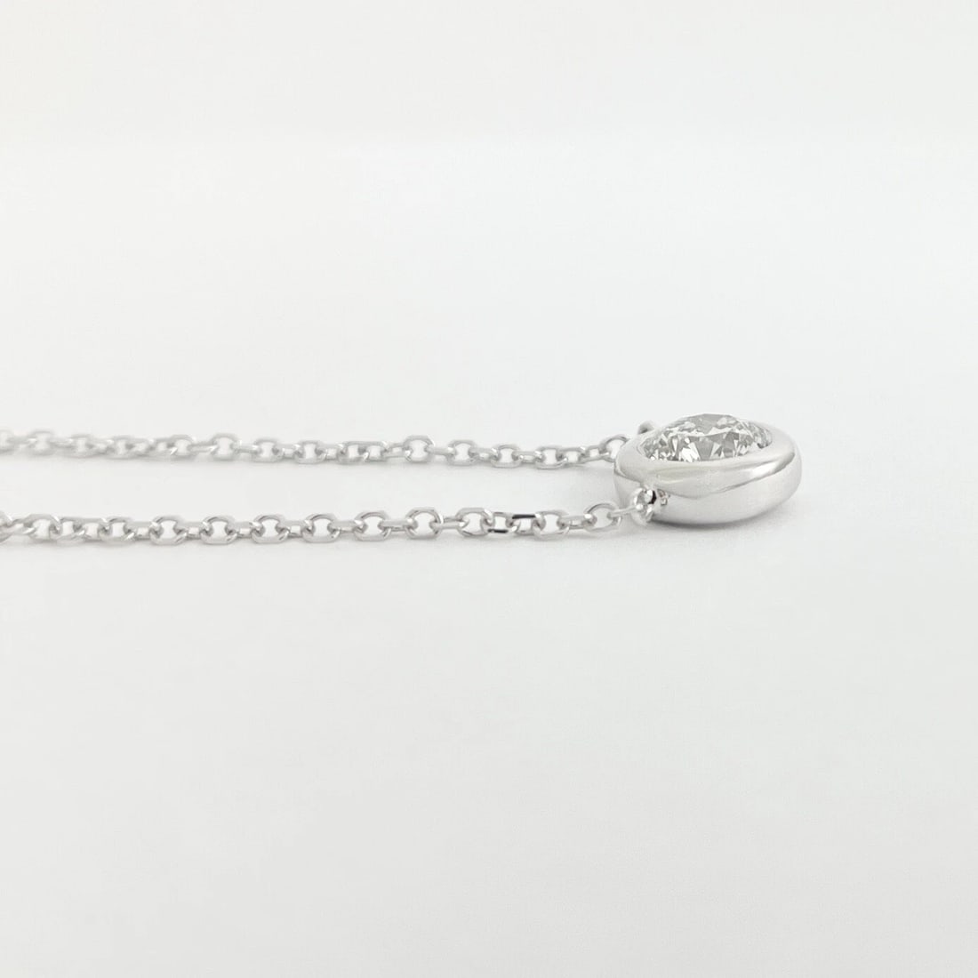 ROUND BEZEL SOLITAIRE DIAMOND PENDANT NECKLACE: Round Bezel Solitaire Diamond Pendant Necklace Brand: None Type: Necklace Material: 14K White Gold, Main Stone/Creation Natural Color: Silver Size: Length: 15 inches Pendant: 9.2 mm 