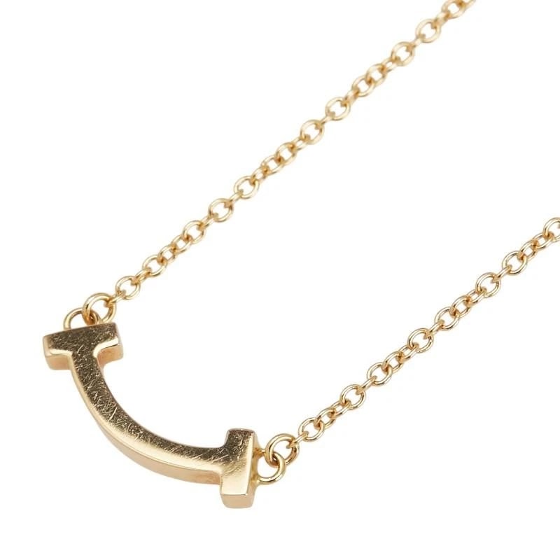 TIFFANY & CO. T SMILE MINI K18YELLOW GOLD NECKLACE: Tiffany & Co. T Smile Mini K18Yellow Gold Necklace Brand: Tiffany & Co. Type/Style: Necklace Material: Metal Purity K18, Metal Yellow Gold, Main Stone/Creation Natural Color: Yellow Gold Size: Tot