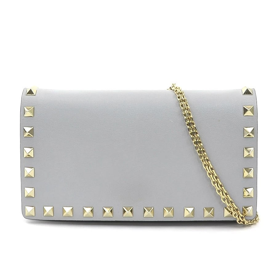 VALENTINO GARAVANI ROCKSTUDS CROSSBODY SHOULDER BAG: Valentino Garavani Rockstuds Crossbody Shoulder Bag Brand: Valentino Garavani Type: Crossbody Shoulder Bag Material: Leather/Metal Color: Light Gray/Gold Size: W:7.1inx H:3.9inx D:1.6in Accessorie
