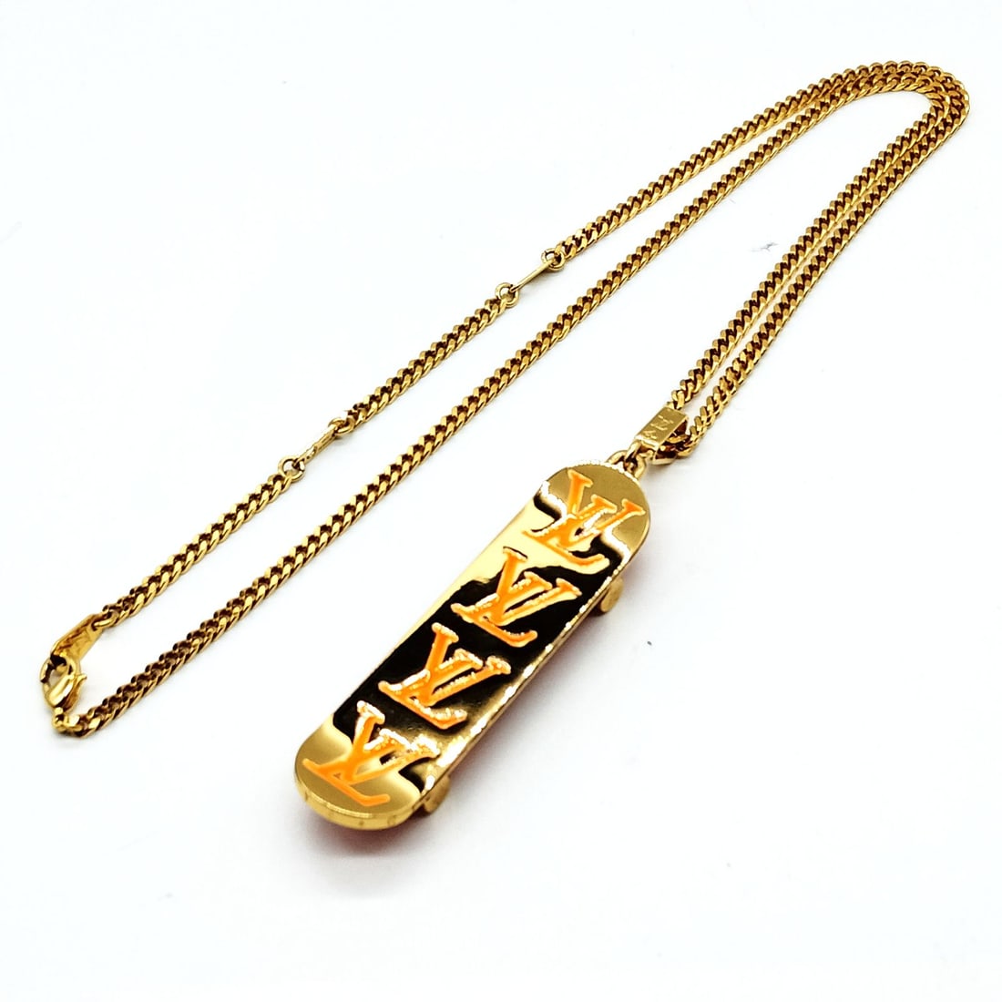 LOUIS VUITTON PENDANT NECKLACE SKATEBORD NECKLACE: Louis Vuitton Pendant Necklace Skatebord necklace Brand: Louis Vuitton Type: Pendant Necklace Material: Metal, Color: Gold Size: Full Length : 59 cm (approx) Size : 1.7x7.1 Accessories: None