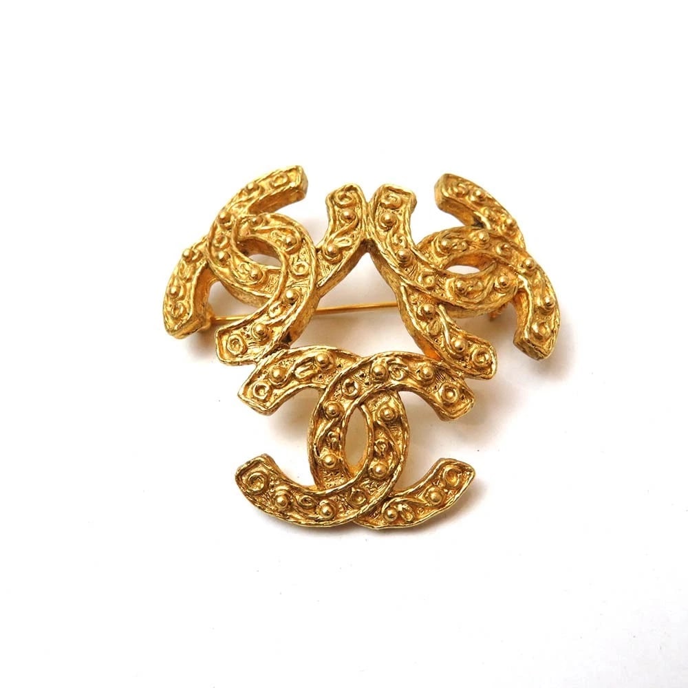 CHANEL TRIPLE CAMO MARK BROOCH GOLD PLATED: Chanel Triple Camo Mark Brooch Gold Plated Brand: Chanel Type/Style: Brooch Material: Gold-plated, Color: Gold Size: approximately 1.8 inches wide x 1.8 inches tall. Accessories: None Accessories