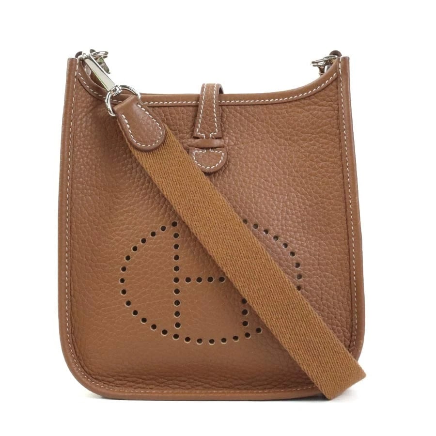 HERMES EVELYNE TPM CROSSBODY SHOULDER BAG: HERMES Evelyne TPM Crossbody Shoulder Bag Brand: HERMES Type/Style: Shoulder Bag Material: Taurillon Clemence Color: Gold Size: Size [inch] (Bottom)W:6.3inx H:6.7inx D:2.0in Size [cm] (Bottom)W:16cmx