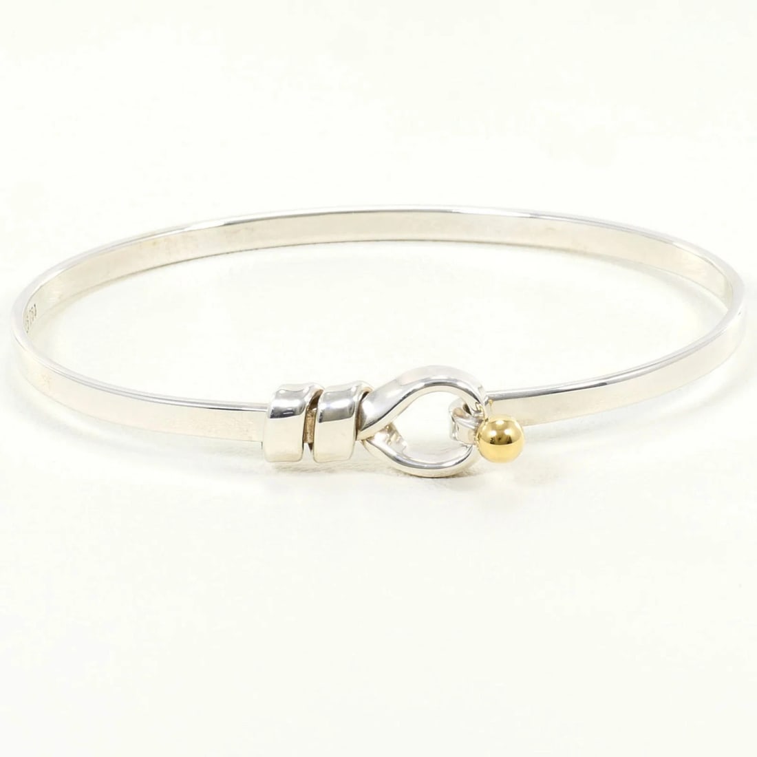 TIFFANY & CO. LOVE KNOT SILVER 18K YELLOW GOLD BANGLE: Tiffany & Co. Love Knot Silver 18K Yellow Gold Bangle Brand: Tiffany Type/Style: Bangle Material: Silver 925 Yellow gold (18K) Color: Silver Size: Length 17.5cm / 6.88'' Accessories: None