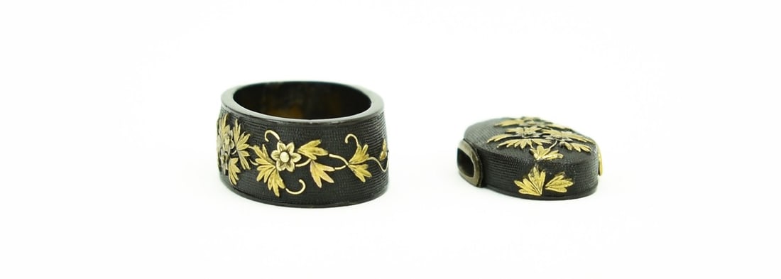 KINKO SET OF KODZUKA, KOGAI, AND FUCHI KASHIRA: Kinko set of Kodzuka, Kogai, and Fuchi Kashira Size: Description: Kinko set of Kodzuka, Kogai, and Fuchi Kashira. Shakudo Nanako ground. Silver peonies with gold leaves and tendrils. Unsigned. Note: