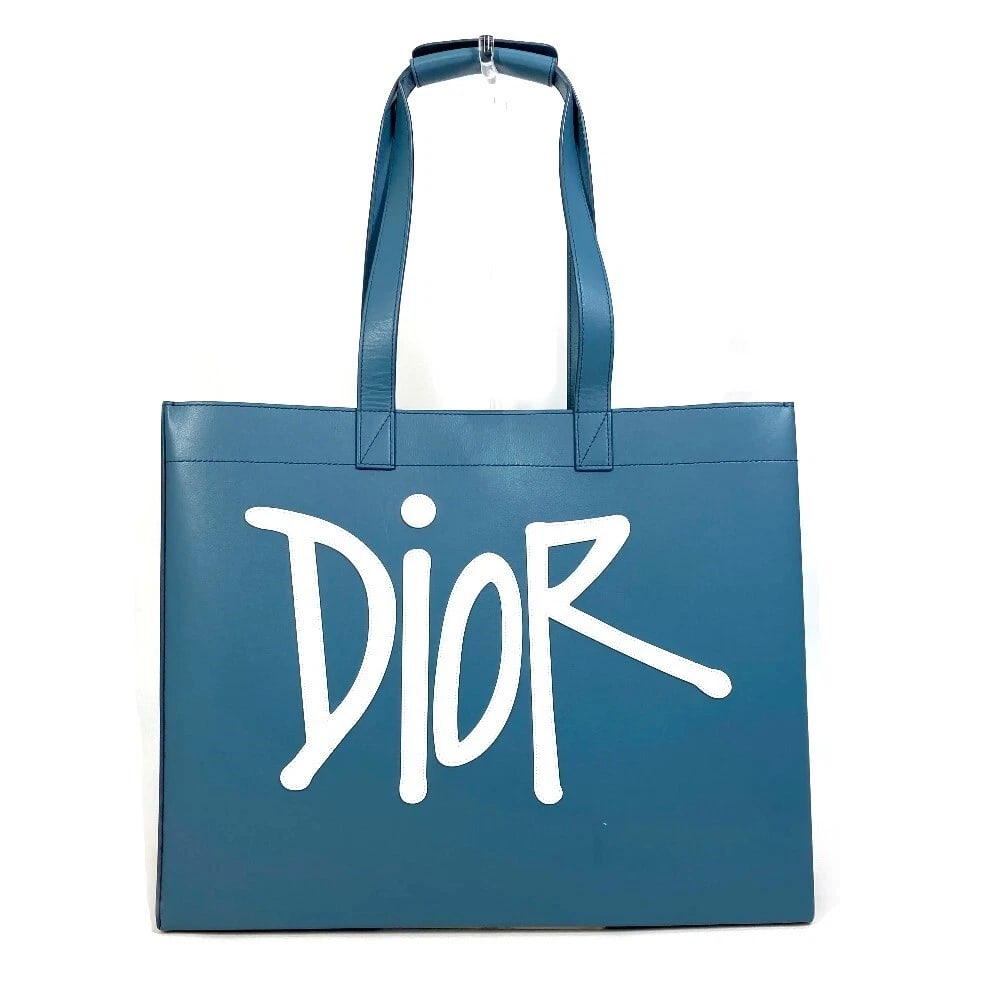 DIOR LOGO SHAWN STUSSY COLLABORATION HAND BAG: Dior logo Shawn Stussy collaboration Hand Bag Brand: Dior Type/Style: Tote Bag Material: Leather Color: Blue Size: W16.5xH13.4xD6.1inch / W42cmxH34cmxD15.5cm Handle: 26.4inch / 67cm Accessories: N