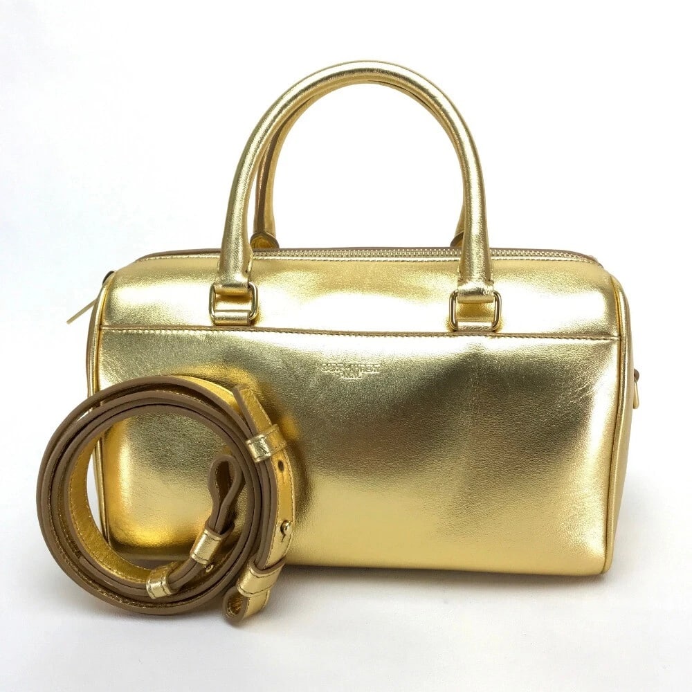 SAINT LAURENT PARIS BABY DUFFLE 2WAY HAND BAG: SAINT LAURENT PARIS Baby Duffle 2WAY Hand Bag Brand: SAINT LAURENT PARIS Type/Style: duffel hand bad shoulderbag Material: Leather Color: Gold Size: W8.9 x H5.5 x D4.1inch / W22.5cm x H14cm x D10.5cm 