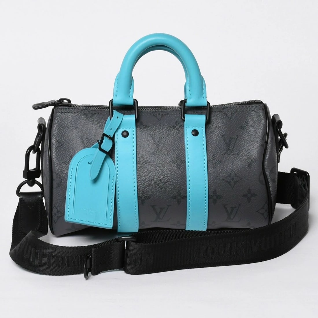 LOUIS VUITTON KEEPALL BANDOULIERE 25 MONOGRAM ECLIPSE HANDBAG: Louis Vuitton Keepall Bandouliere 25 Monogram Eclipse Handbag Brand: Louis Vuitton Type/Style: Top Handle Bag Material: PVC Coated Canvas / Leather Color: Black / Gray / Turquoise Size: Width: 9.84 in