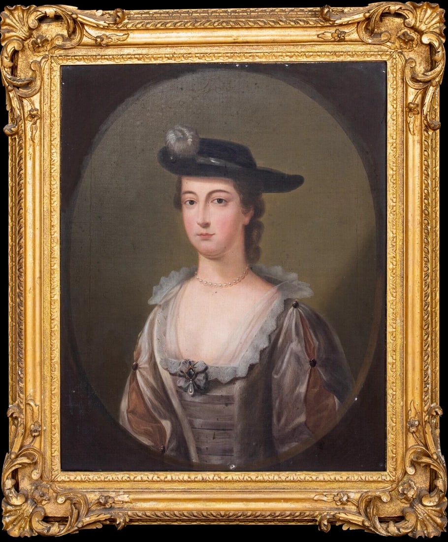 PORTRAIT OF MARY ANNE WARD OIL PAINTING: Year: 18th century Size: 38.5" x 33" Medium: Oil Description: An oil painting from the 18th century depicting a woman in a horse-riding hat. The little girl in her riding clothes, surrounded by an ova