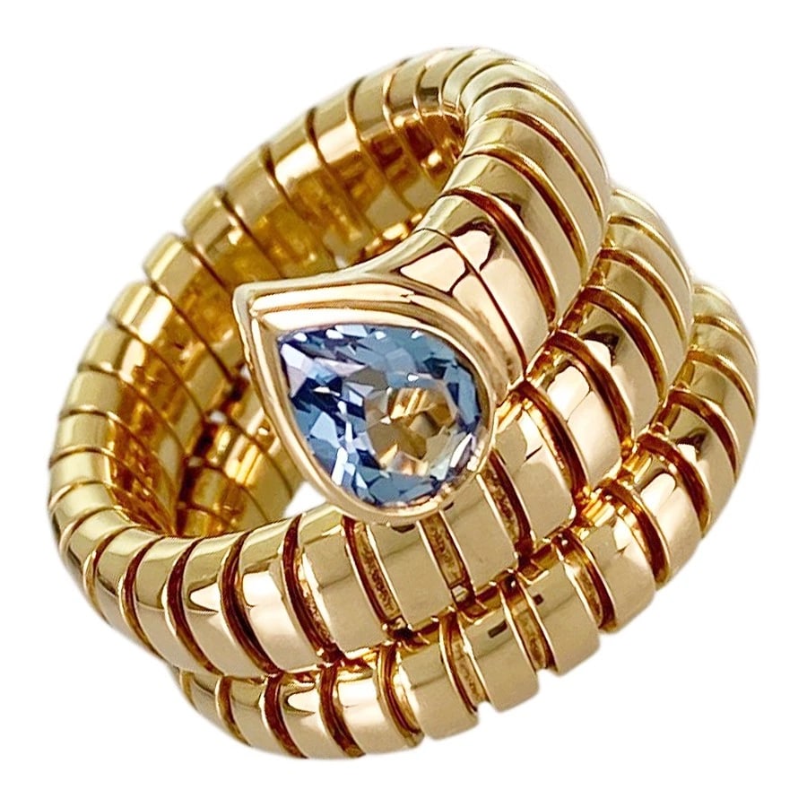 BVLGARI TUBOGAS YELLOW GOLD BLUE TOPAZ RING: BVLGARI Tubogas Yellow gold Blue Topaz Ring Brand: BVLGARI Type/Style: Ring Material: 18K Yellow Gold Main Stone Topaz Color: Gold Size: US 4-4.5 Accessories: None Accessories Notice: When