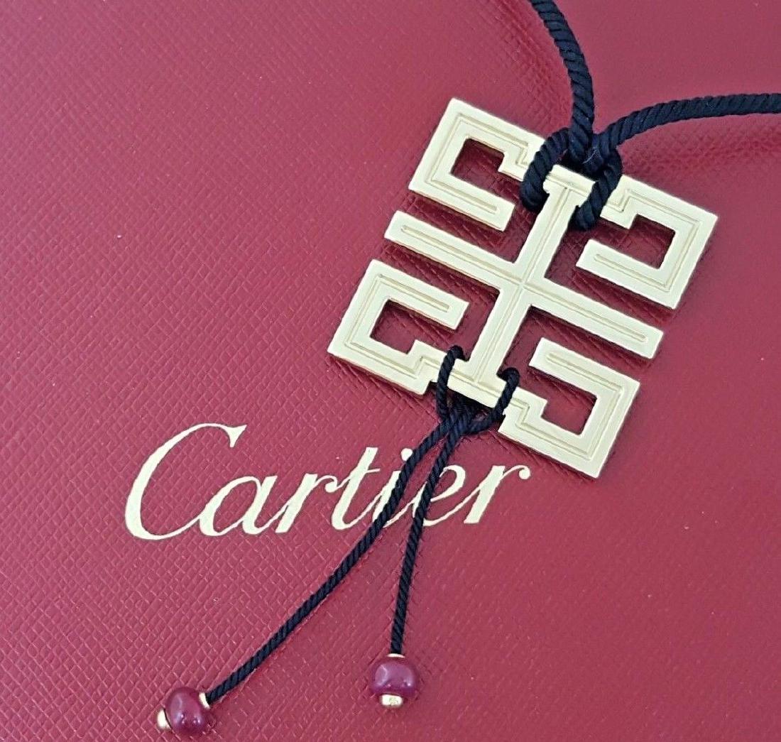 Cartier Le Baiser Dragon Ruby Pendant / Necklace 20": Cartier Le Baiser Dragon Ruby Pendant / Necklace 20". The pendant weighs 23.8 grams and has adjustable 21" Silk Cord. The pendant is stamped "Cartier 750 © 16504A *1TO". The measurements of the Penda