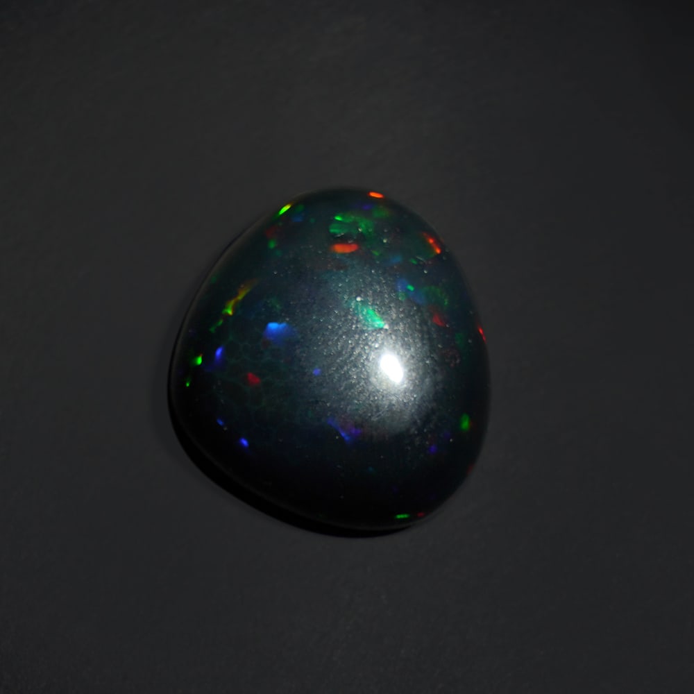 15.50 ct. Natural Play of Color Opal - ETHIOPIA: 15.50 ct. Natural Play of Color Opal - ETHIOPIA Shape - Cabochon Color -Play of color Clarity - Opaque Ct. Weight - 15.50 ct. Origin - ETHIOPIA C