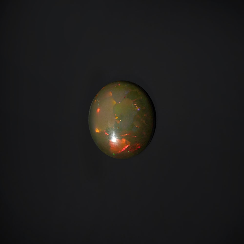 16.90 ct. Natural Play of Color Opal - ETHIOPIA: 16.90 ct. Natural Play of Color Opal - ETHIOPIA Shape - Oval Cabochon Color -Play of color Clarity - Opaque Ct. Weight - 16.90 ct. Origin - ETHIOPIA