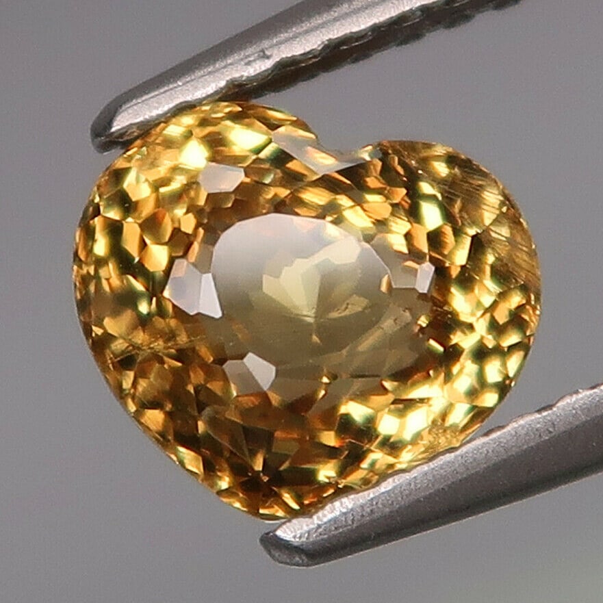 RARE IGI Cert. 1.99 ct. Natural Malaya Garnet - AFRICA: RARE IGI Certified 1.99 ct. Natural Garnet - AFRICA Color - Greyish Yellow Clarity - VS Cut - Heart Mixed cut Ct. Weight - 1.99 ct. Dimensions - 6.45 x 7.41 x 5.34 mm <